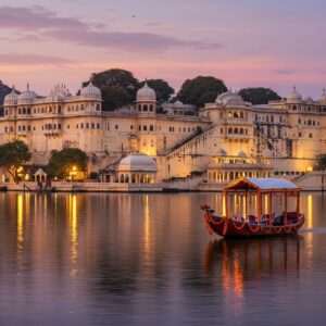 A majestic view of Udaipur's City Palace, majestically perched over Lake Pichola at sunset. The palace, with its intricate arches and domes, is bathed in warm, golden light, reflecting in the tranquil lake. In the foreground, a traditional Indian boat floats gently on the water, adorned with vibrant marigold garlands. The sky is painted with soft hues of pastel pink and purple, while ethereal lights twinkle around the palace, giving it a magical aura. In the distance, the Aravalli hills provide a serene backdrop. The art style should blend traditional Indian motifs with modern digital aesthetics, capturing the essence of Udaipur's royal legacy and spirituality.