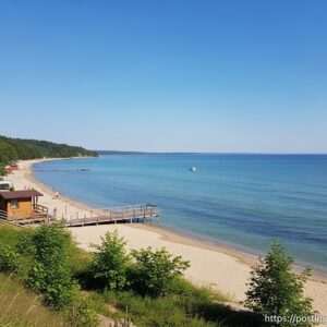 A serene and enchanting scene of Haldia's Eco Park Beach with the golden sun setting over the horizon, casting a warm glow on the tranquil waters of the dam. The beach is depicted with lush green foliage and vibrant wildflowers along the shore. In the foreground, a peacock is gracefully walking, its feathers shimmering with hues of blue and green. The sky is adorned with soft pastel colors, blending seamlessly into the water, creating a dreamlike reflection. A small group of Indian people are seen enjoying the peaceful surroundings, some walking along the beach and others sitting on a wooden bench, lost in contemplation. The art style is hyperrealistic with an ethereal touch, capturing the natural beauty and tranquility of Haldia's landscape. The scene conveys a sense of harmony between nature and humanity, inviting readers to explore and embrace the serene environment.