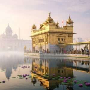 An ethereal depiction of Harmandir Sahib, the iconic Sikh temple, bathed in a serene, golden glow under the soft light of dawn. The temple is reflected in the calm waters of the surrounding holy lake, with delicate lotus flowers floating on the surface. The scene captures intricate architectural details, with the temple's gold-plated exterior and shimmering domes. A few Indian devotees, dressed in traditional attire, are seen walking towards the temple, their figures silhouetted against the warm, radiant sky. The atmosphere is peaceful and reverent, with a subtle hint of pastel colors in the sky, creating a blend of modern digital aesthetics with traditional Indian artistry. This image exudes spirituality, history, and cultural significance, drawing readers into the sacred narrative.